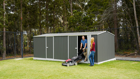Absco 20' x 10' Woodland Gray Metal Shed in a backyard setting with people and lawnmower.