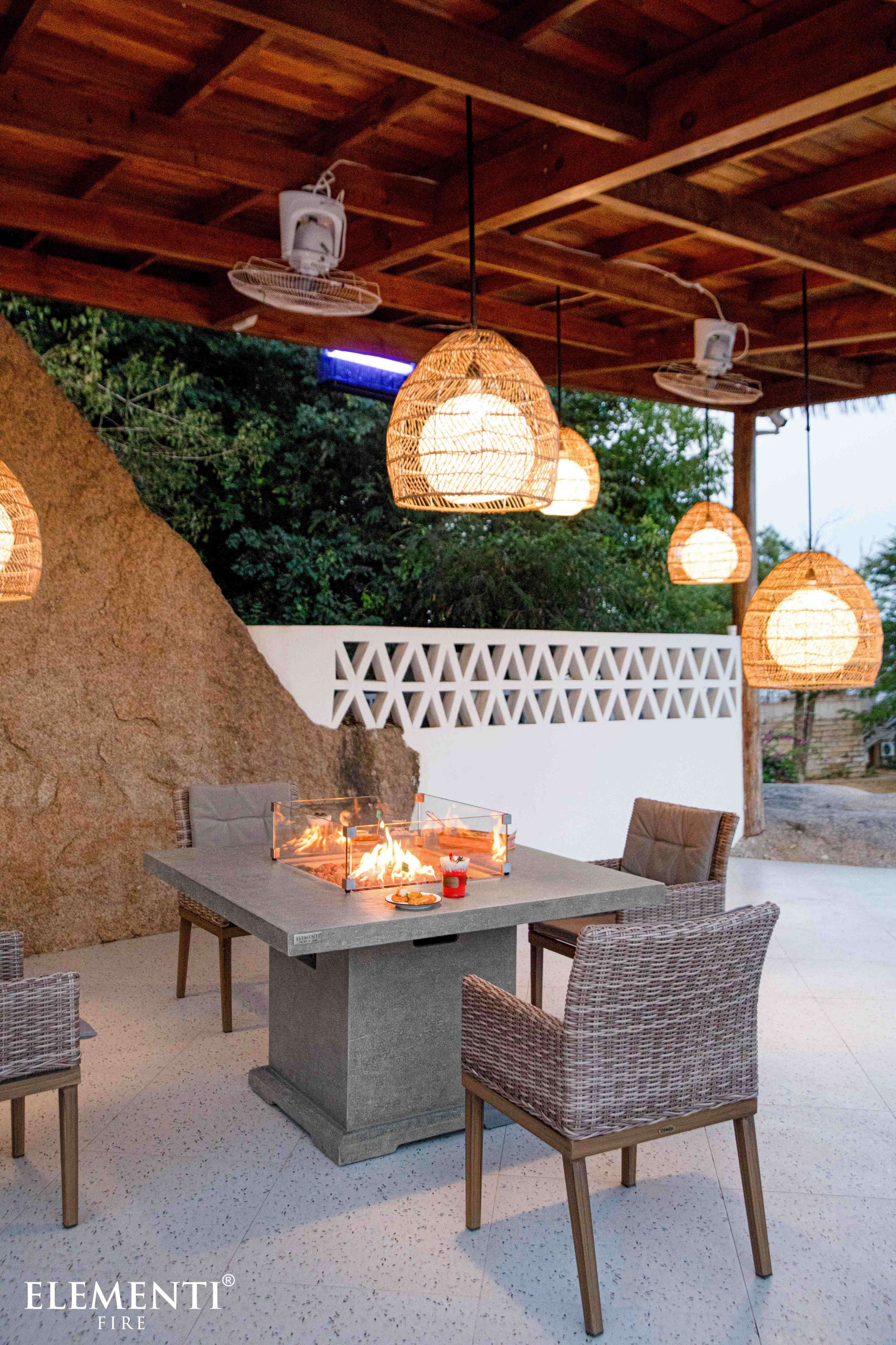 A stylish patio with the Elementi Birmingham Dining FirePit Table, ideal for outdoor dining and enjoying a fire pit ambiance