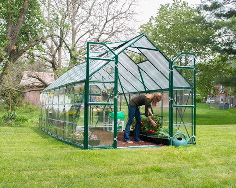 Canopia Balance 8' Greenhouse in Green with woman watering plants inside.