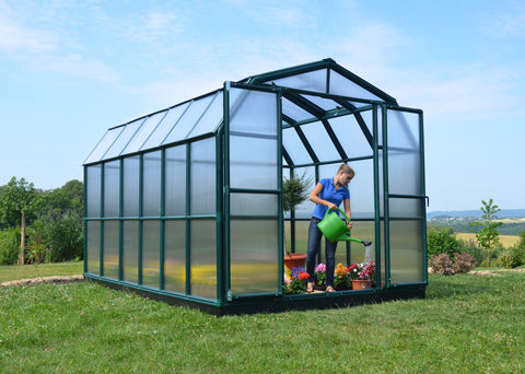 Canopia Grand Gardener 8x12 Greenhouse - Twin Wall with woman inside watering plants.