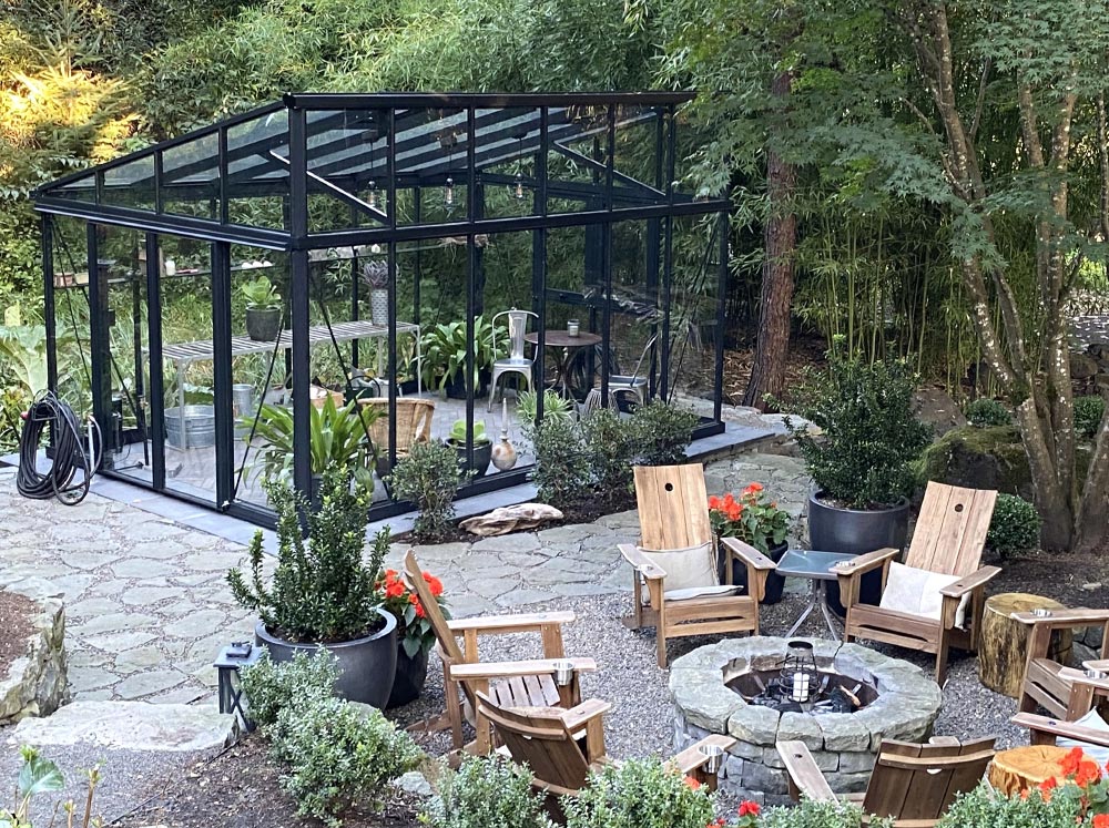 The Exaco Janssens modern greenhouse with a sloped roof stands out against a wintry landscape, offering a warm and well-lit refuge for plants and people alike.