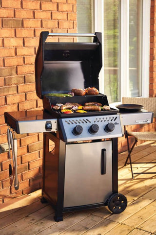 Napoleon Grills Freestyle 365 3-Burner Gas Grill open with sausages and vegetables grilling.