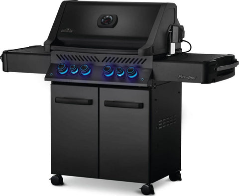 Angled view of Napoleon Grills Phantom Prestige 500 RSIB 6-burner grill with side tables extended and illuminated control knobs.