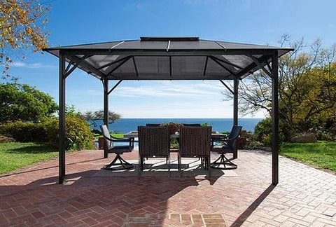 =Paragon Outdoor Madrid Hard Top Gazebo overlooking the ocean, with a dining set ready on the table.