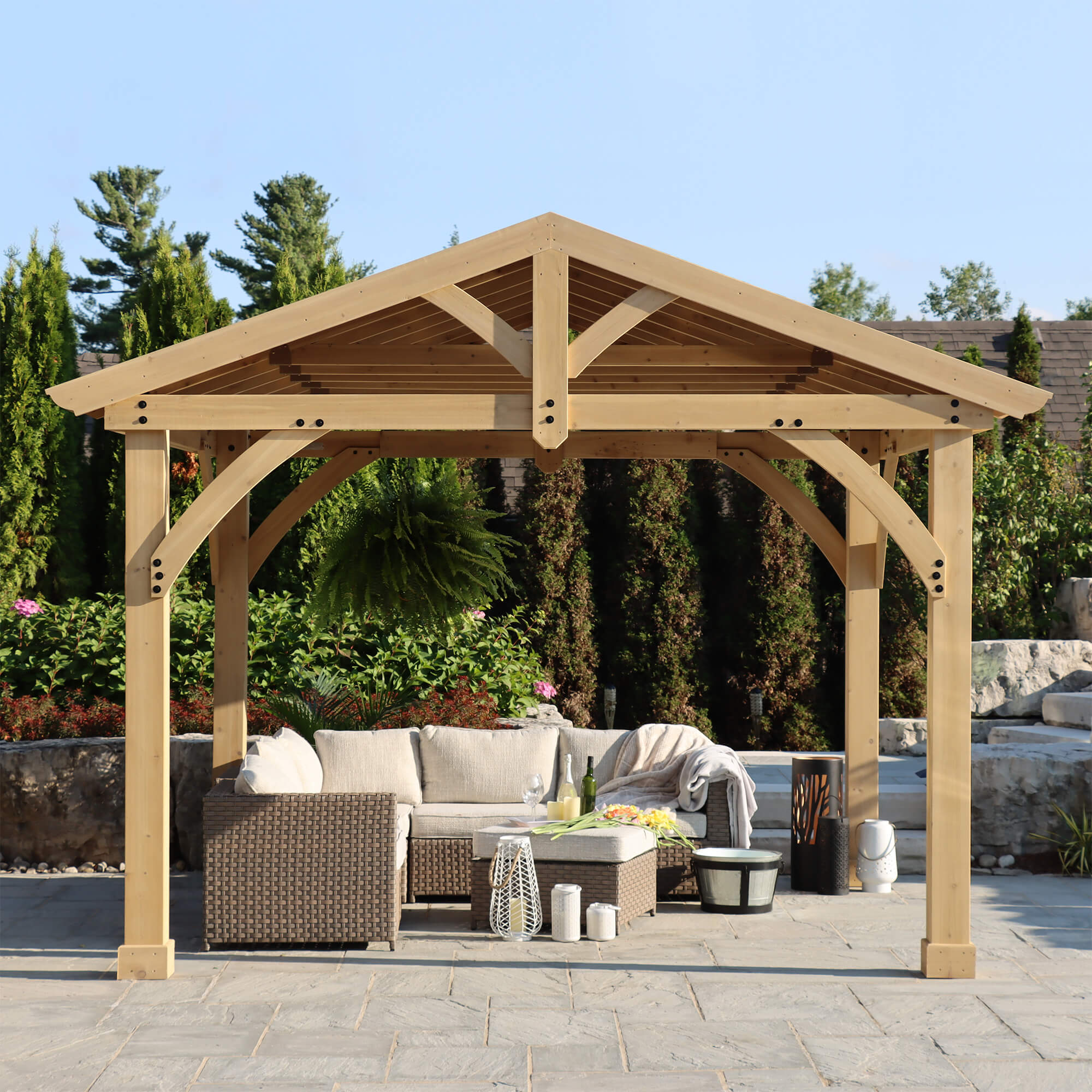 Elegant outdoor seating area enhanced by the Yardistry Carolina Cedar Pavilion, featuring an 11 x 13 aluminum roof, set within a lush garden.