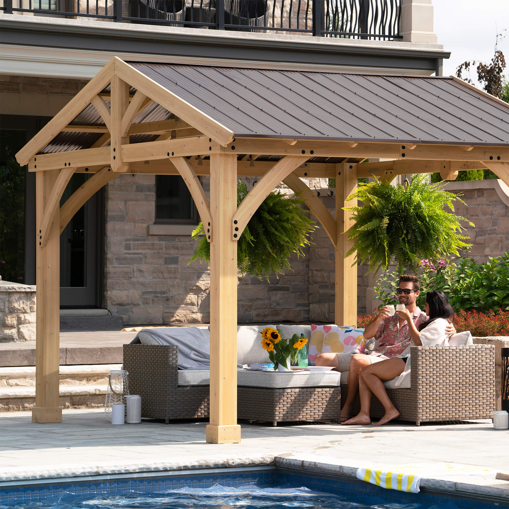 Stylish shelter provided by the Yardistry Carolina Cedar 11 x 13 Pavilion with Aluminum Roof, perfect for enhancing a poolside leisure area.