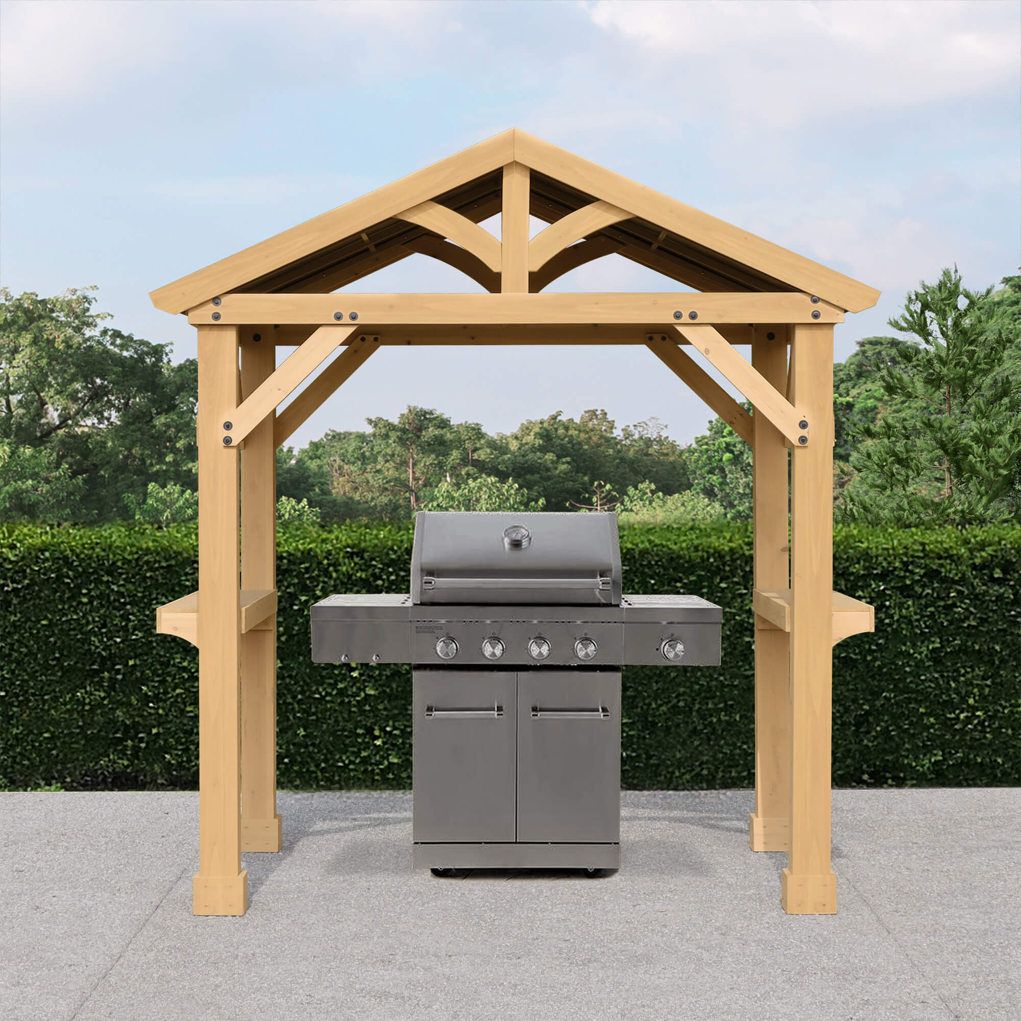 Yardistry Meridian Cedar Grilling Pavilion featuring a robust wooden structure designed to shelter a barbecue grill, set against a backdrop of lush greenery.