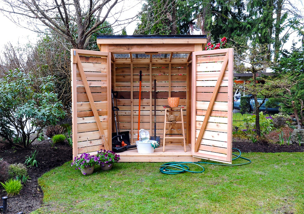 cedar garden shed with open double doors and gardening tools inside