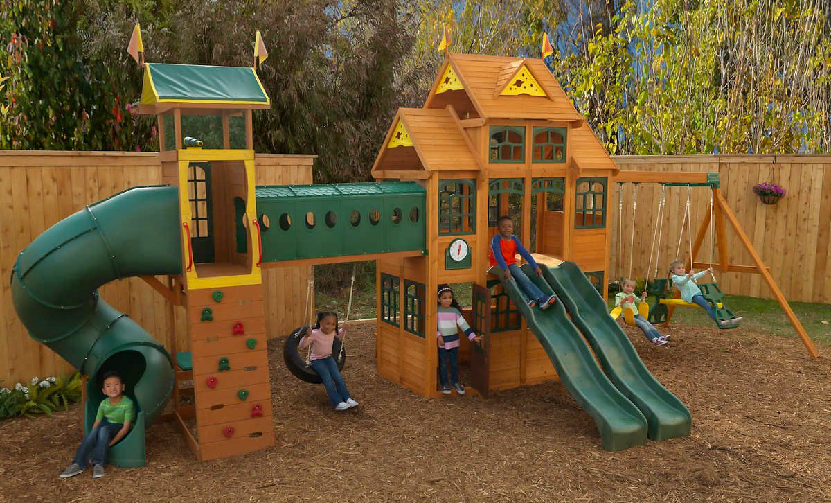 children playing on large cedar playset with many features