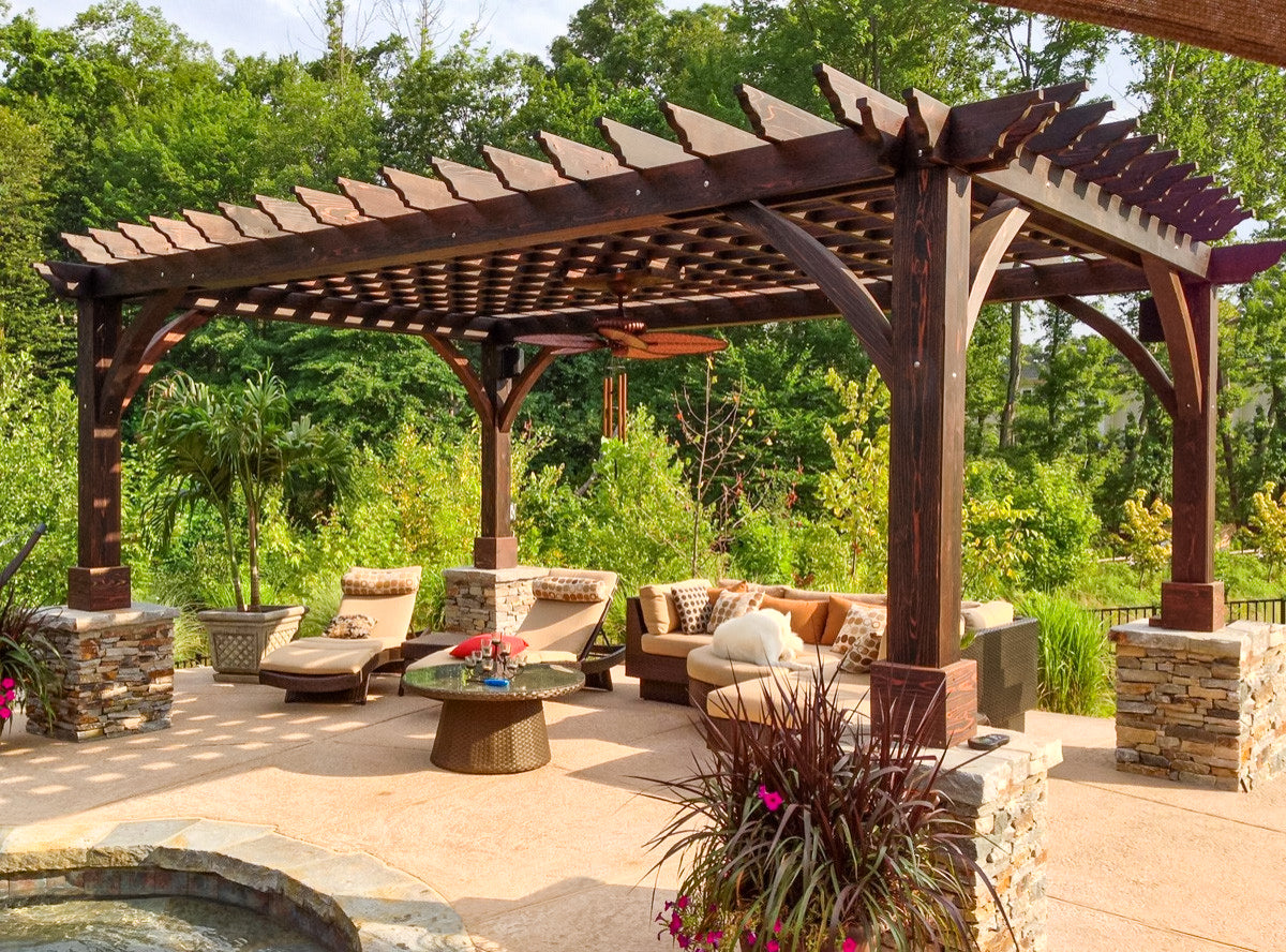 dark stained pergola with outdoor furniture
