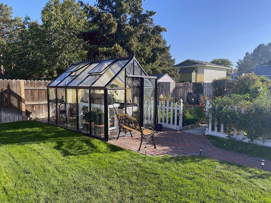 Charming Exaco Janssens Junior Victorian Greenhouse in a serene backyard with a white picket fence and manicured lawn.