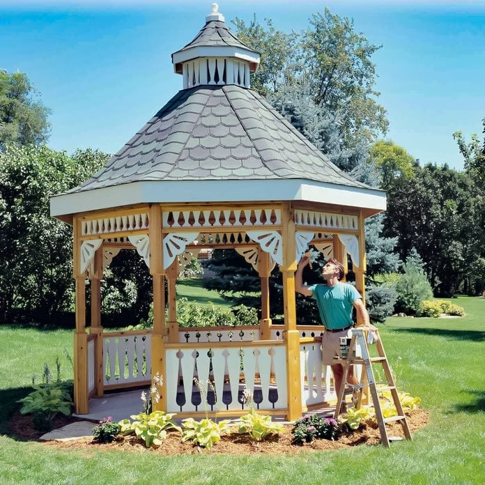 man painting a hexagon gazebo