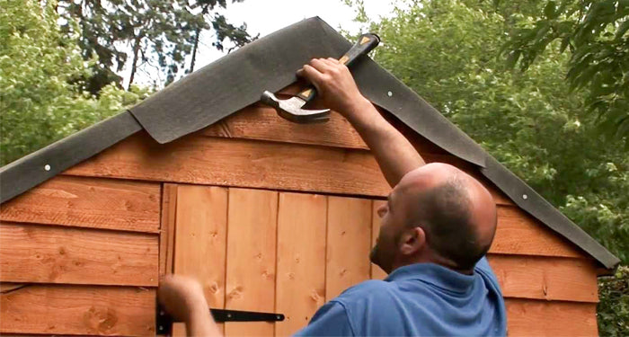 man repairing a sheds roof