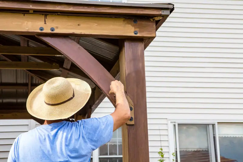 man with a hat painting a gazebo