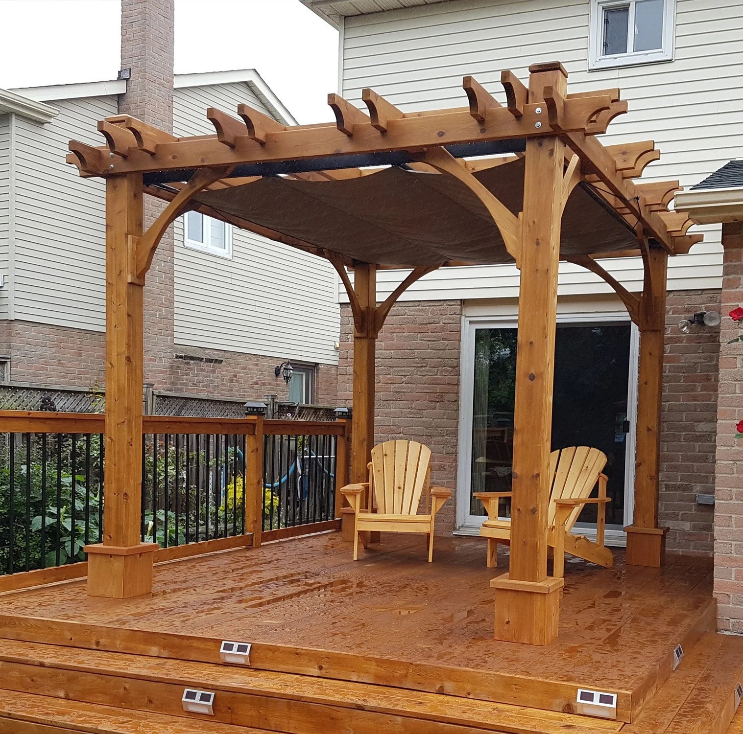 Outdoor Living Today Pergola with Retractable Canopy outdoor lounge chairs on a wooden deck