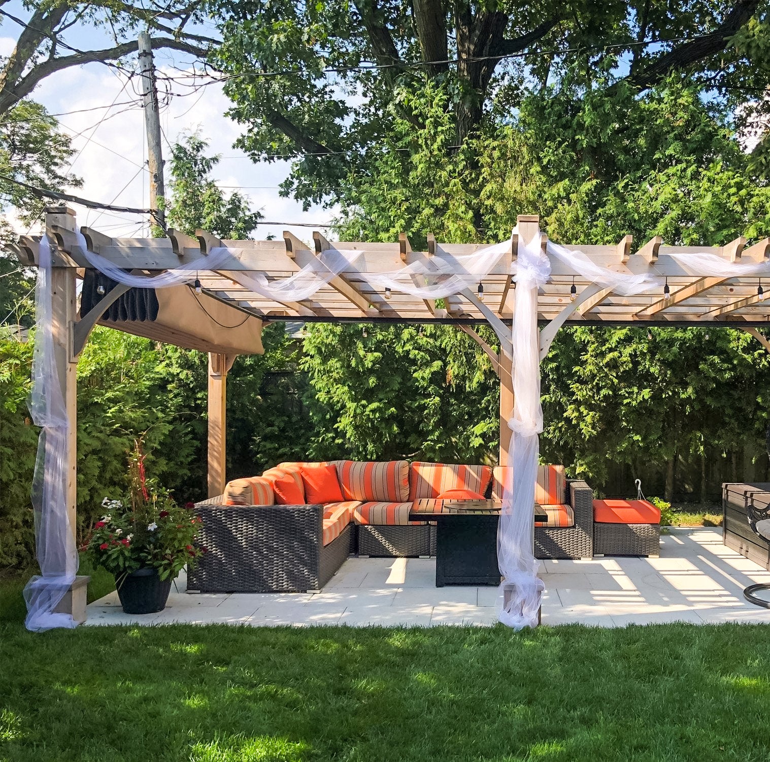 outdoor living today pergola with retractable canopy and string lights and outdoor furniture