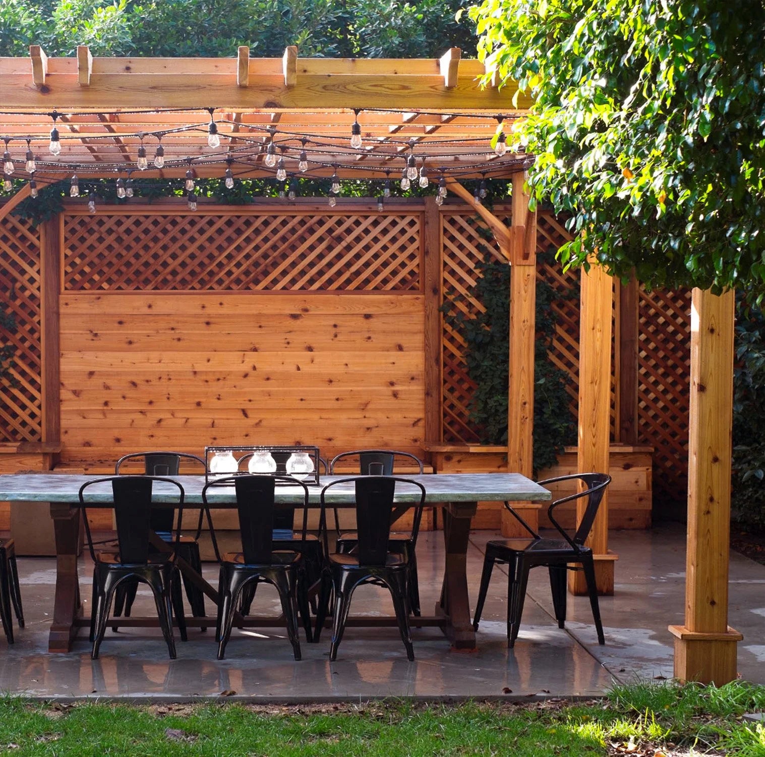 outdoor living today pergola with string lights and outdoor dining set