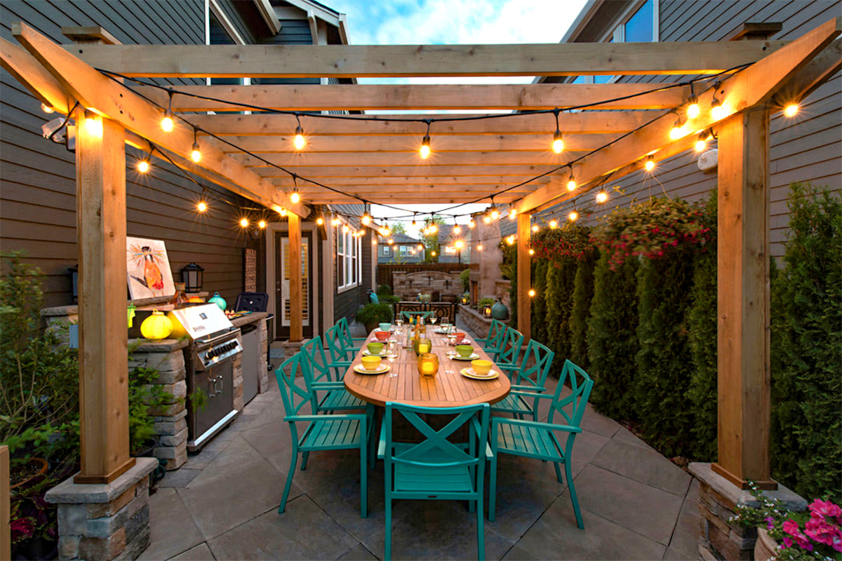 pergola with outdoor string lights and outdoor dining set and grill