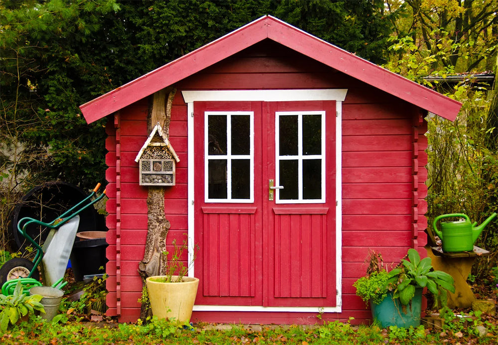 red wooden storage shed with double doors and transom windows