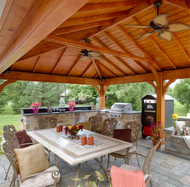 two ceiling fans in a gazebo with outdoor dining set