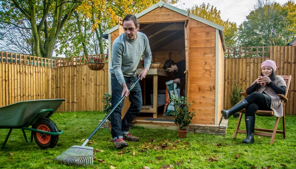 two men cleaning inside and outside the wooden shed