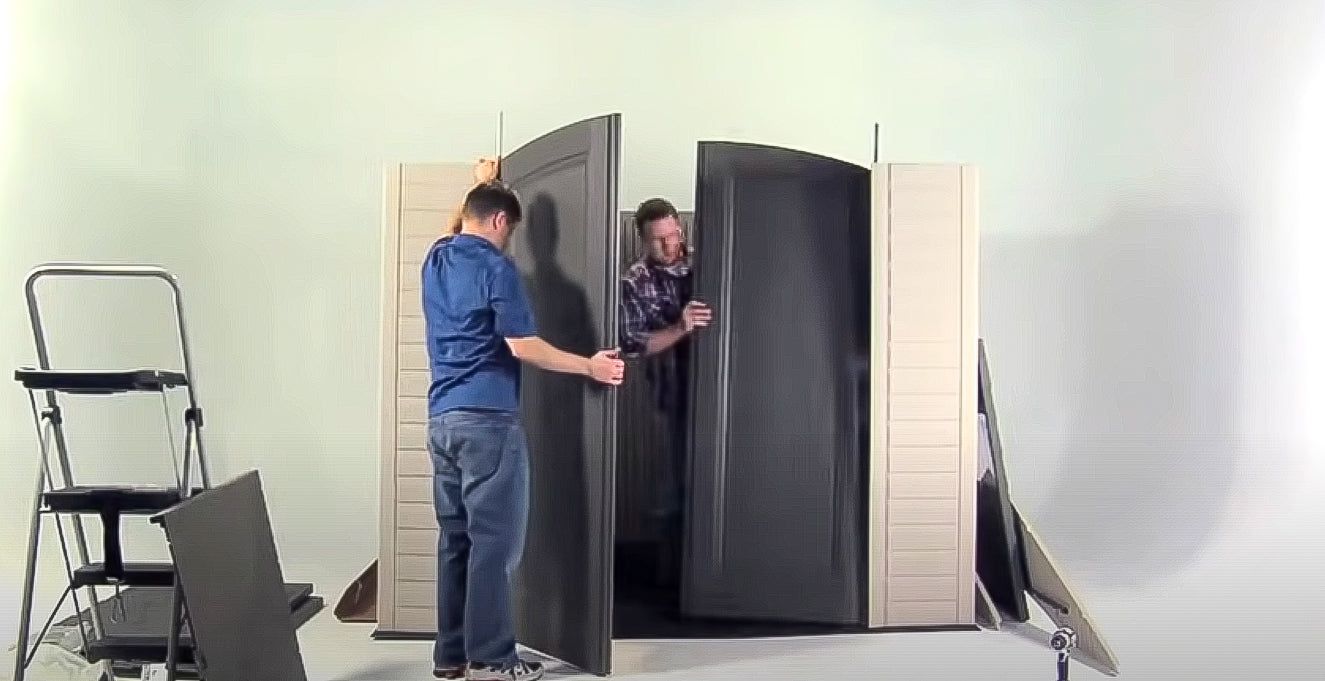 two men installing double door of lifetime storage shed