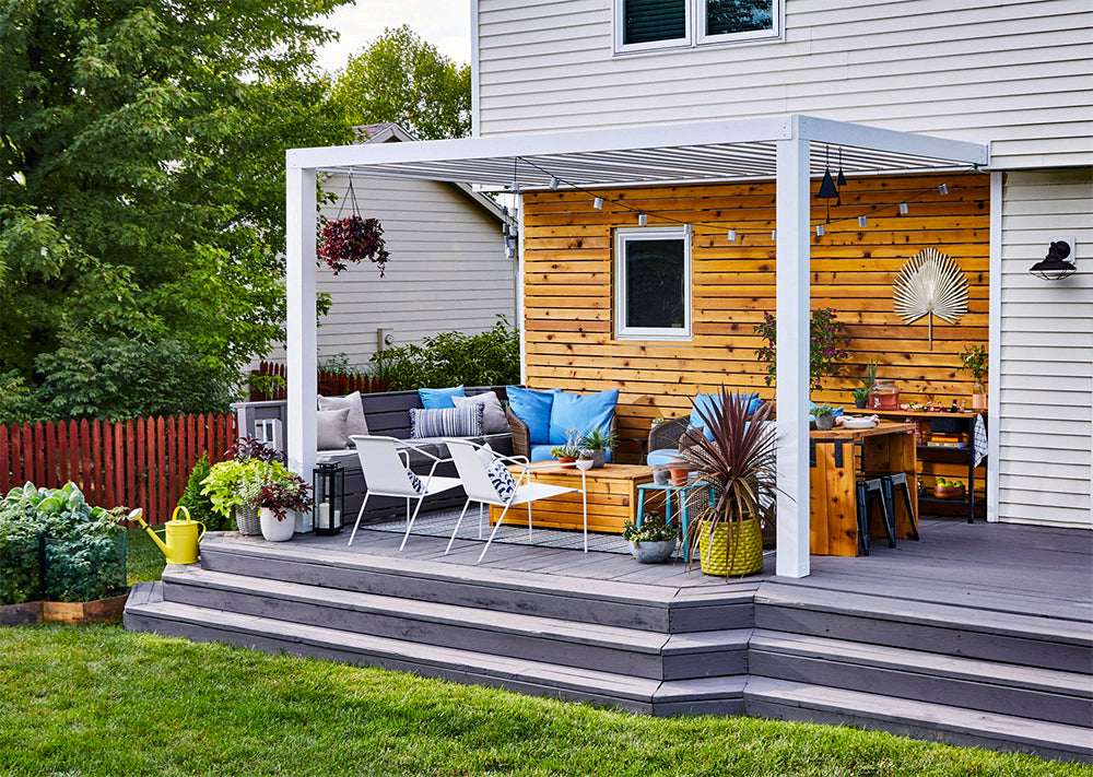 white pergola attached to a house with outdoor furniture on a deck