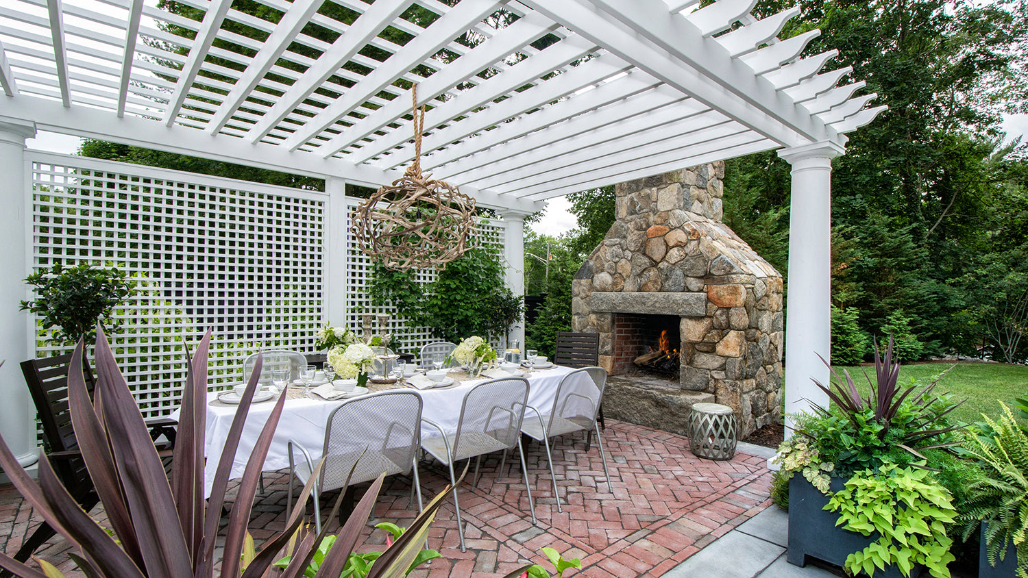white pergola with trellis and outdoor furniture with fireplace