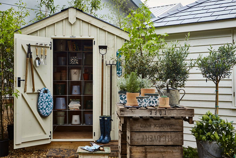 white storage shed with shelves with pots inside