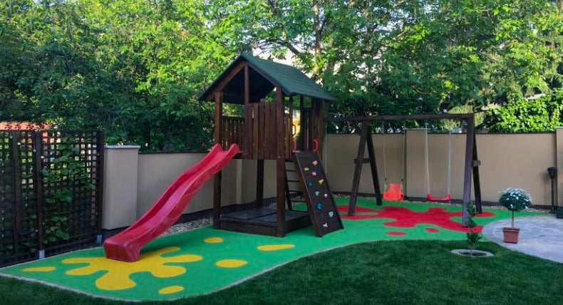 wooden playset with one slide and rockwall on poured rubber