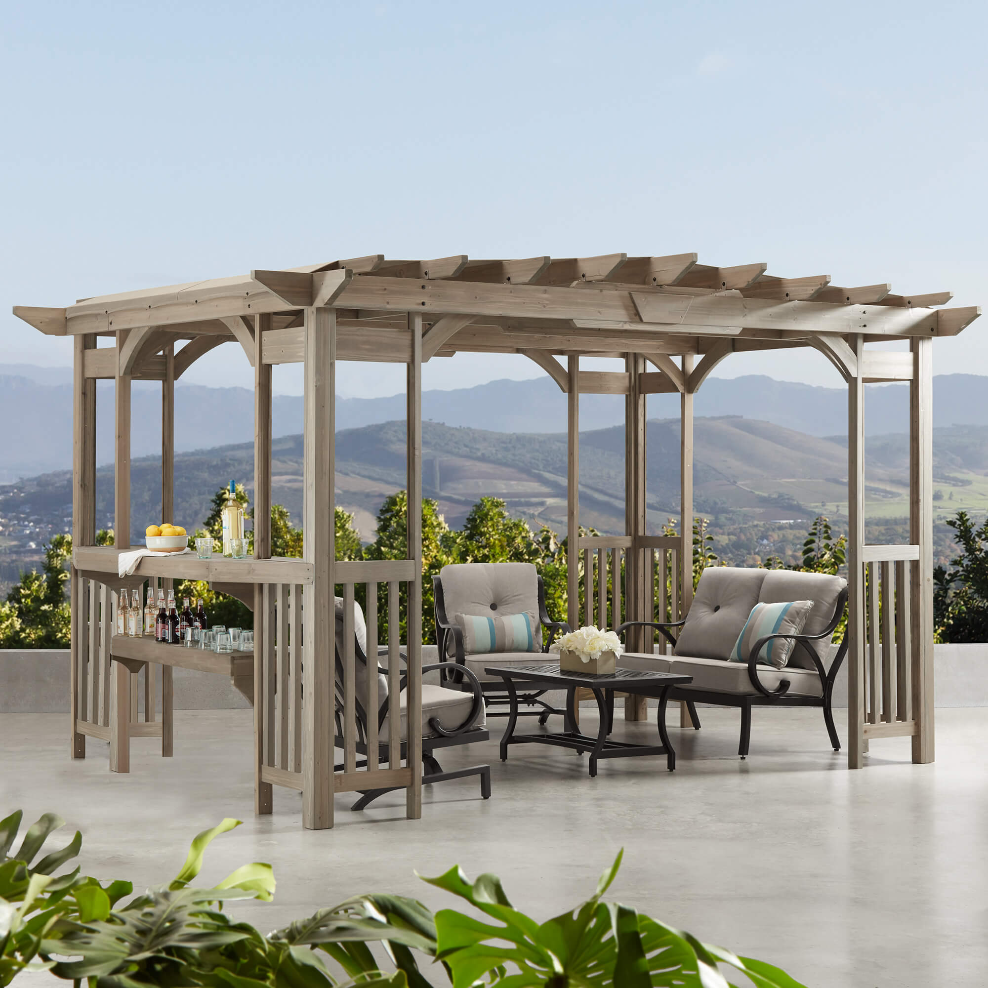 Yardistry Madison Cedar Pergola in Timber Gray, size 10 x 14, beautifully showcased on a panoramic terrace with a stunning mountainous background, perfect for luxurious outdoor lounging.