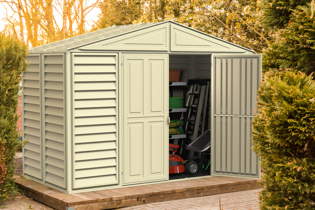 Duramax Woodbridge 5 shed in a real-life outdoor setting, door open showing storage possibilities including garden tools and equipment, blending seamlessly with natural surroundings.