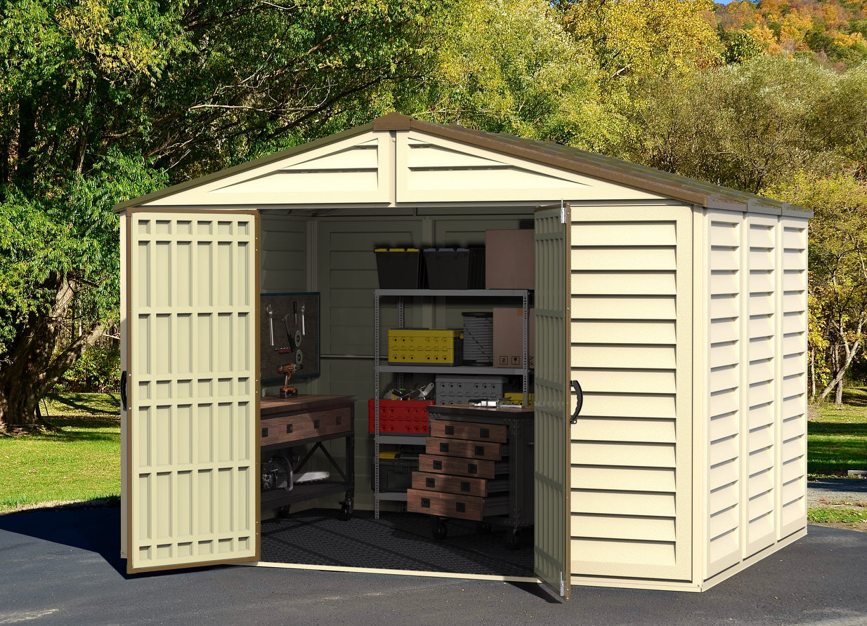 pen view of Duramax Woodbridge Plus 10.5x8 Shed showing spacious interior setup with tools and storage in a natural setting.