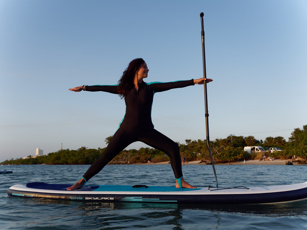 Warrior one pose on an inflatable paddle board