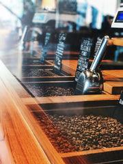 Table with coffee beans and silver scoops in bulk bins