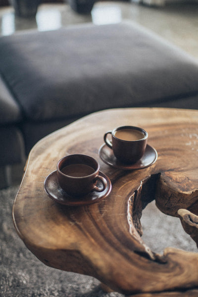 Two cups of mold-free coffee on wooden table.