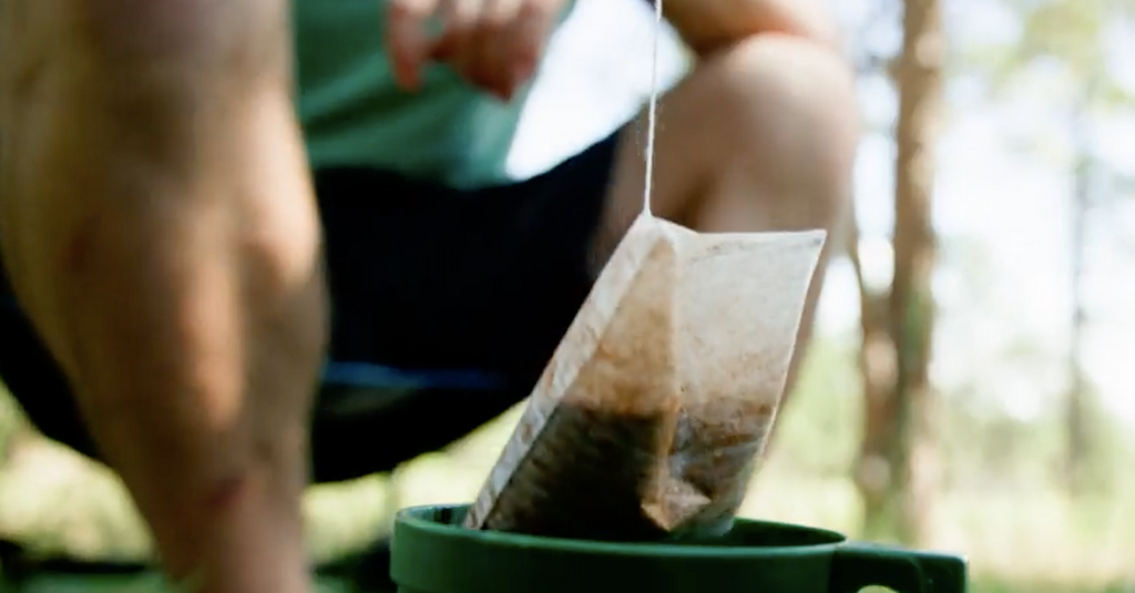 Man dunking Steeped Coffee bag in a mug.