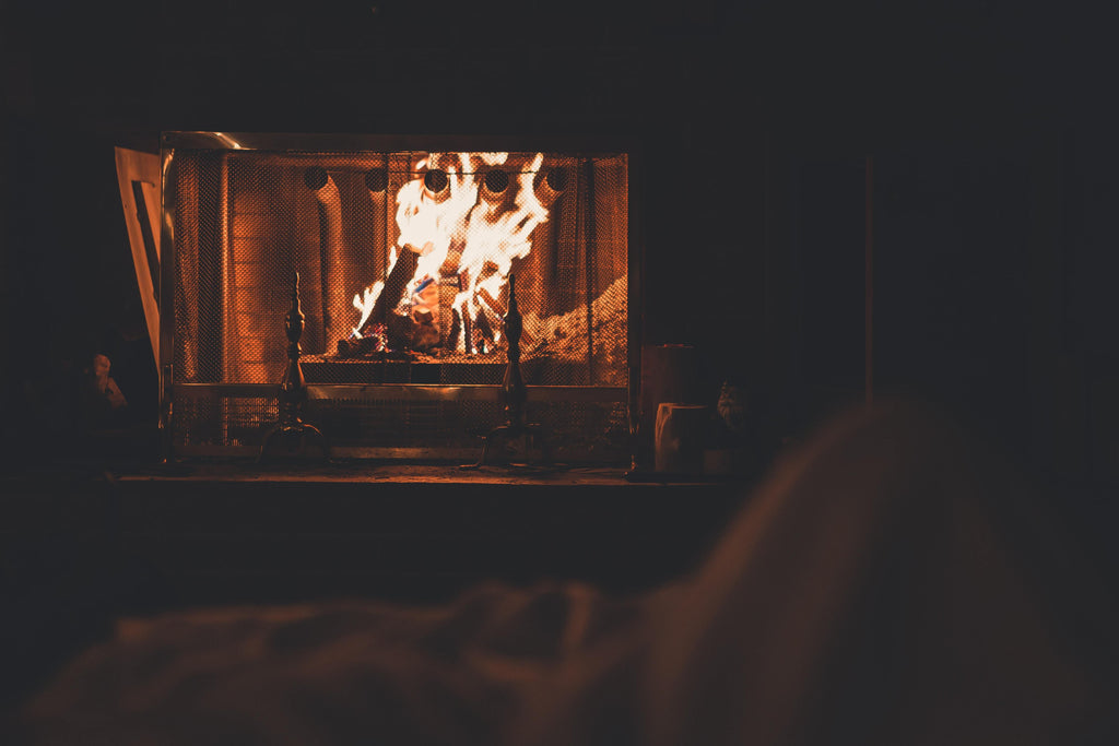 Fireplace burning in a dark room.