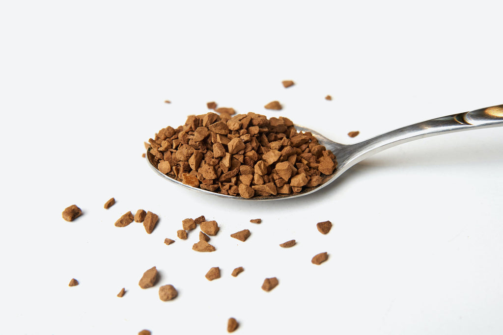 Instant coffee granules on a spoon.