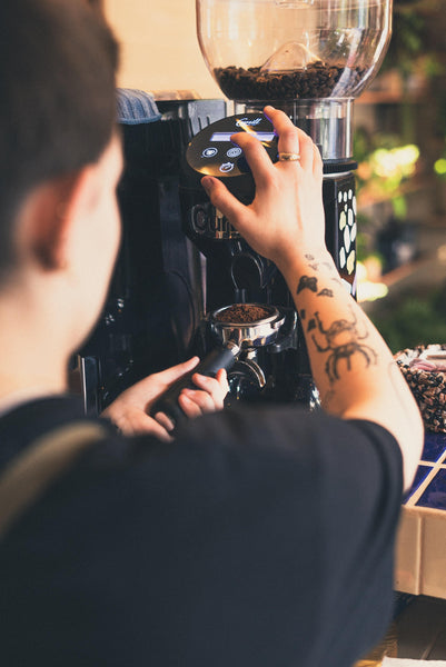 Man preparing coffee in café.