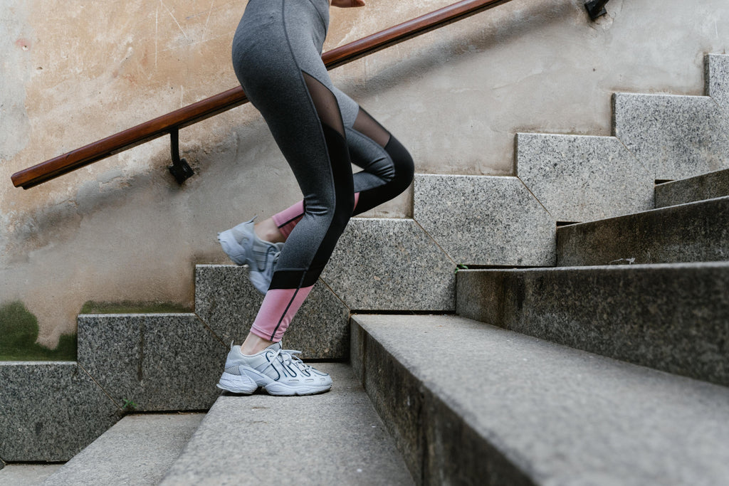 Young woman running up a set of stairs.