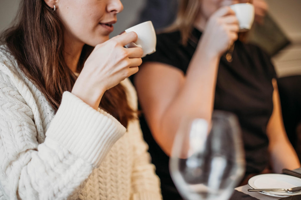 Friends sipping cups of espresso in a café.