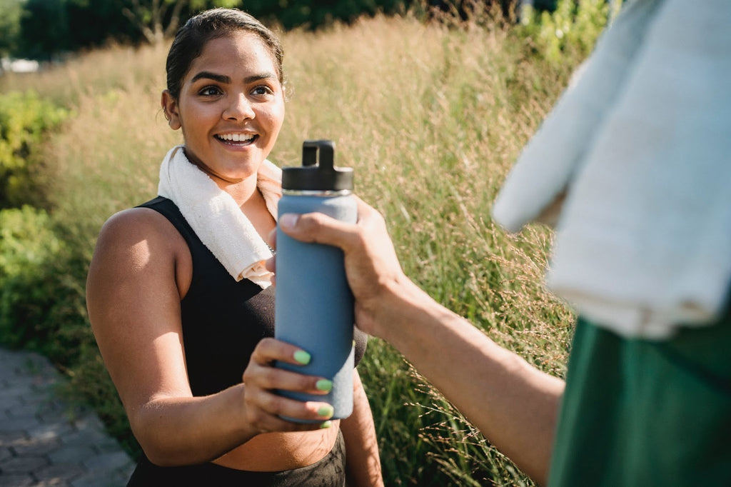 Woman hydrating after a workout in countryside.