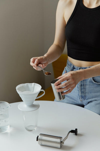 Woman preparing coffee at home.