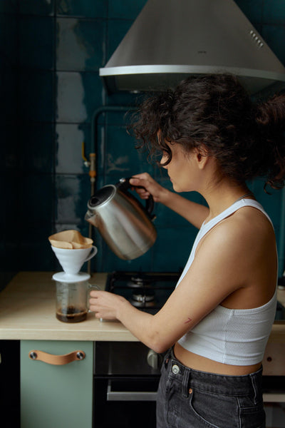 Young woman making morning coffee in the kitchen.