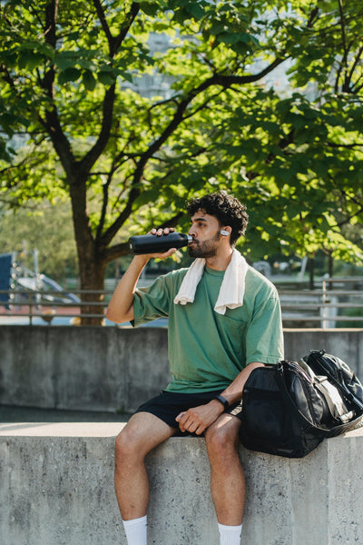 Young man drinking water from bottle after workout.