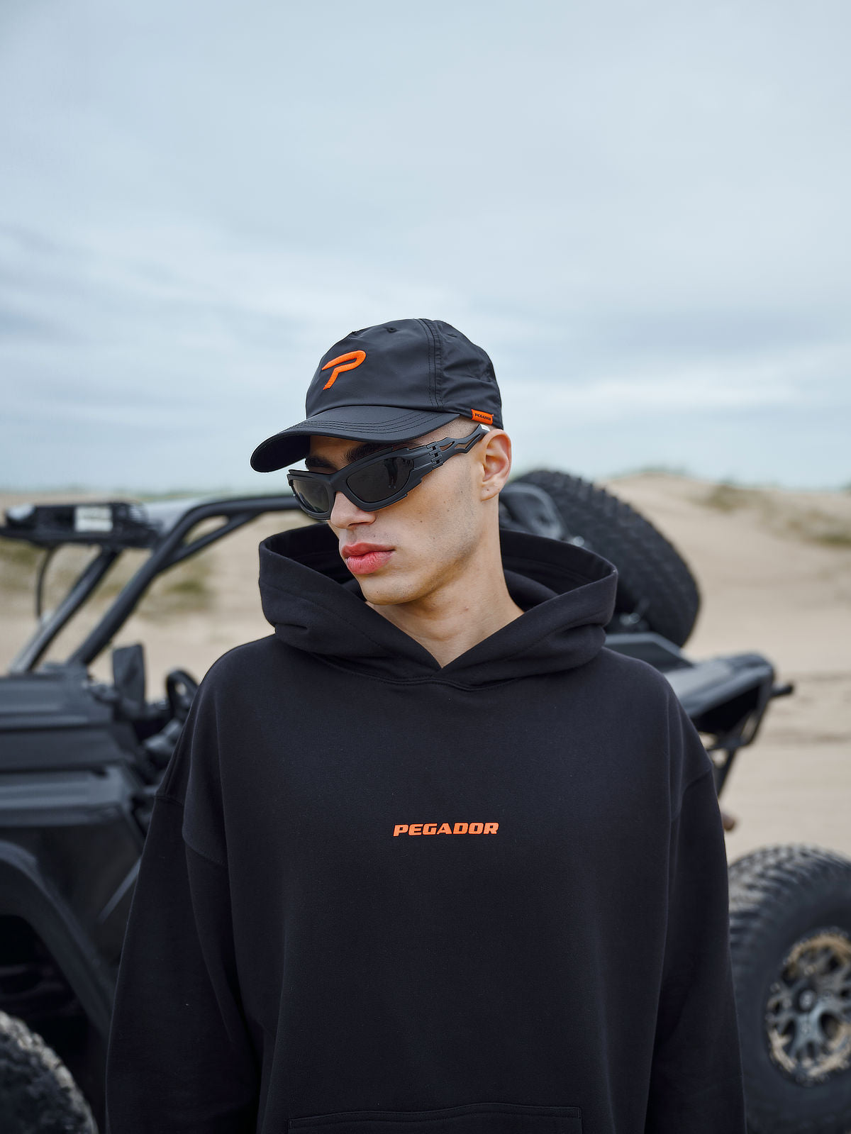 Colne Logo Oversized Hoodie Black Signal Red from the 'Do Not Disturb' collection, designed for comfort and relaxation, set against a serene background, symbolizing a break from the fast-paced world.