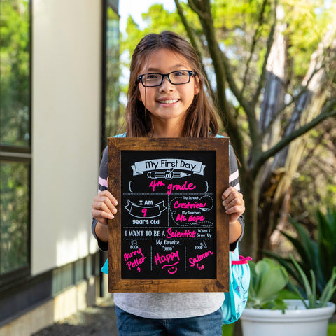girl holding a chalkboard on her first day of school