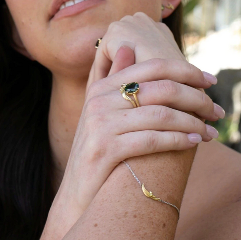 woman-wearing-gold-bracelet-and-ring-with-hand-on-chin