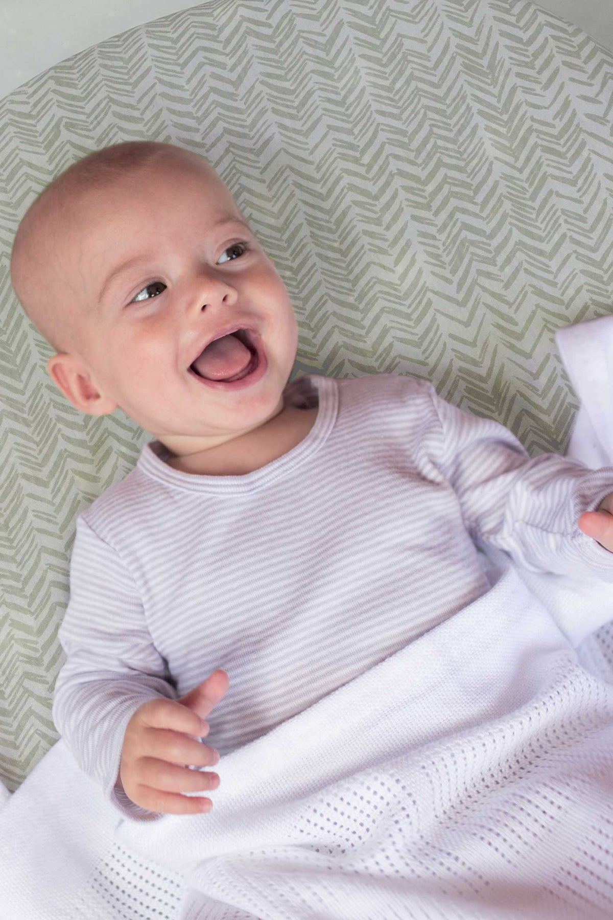 Baby Happy at bed with Herringbone Whisper Whisper and Cellular Blanket Cot